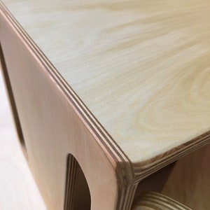 May include: A wooden storage box with three compartments. The box is made of light-colored plywood with visible layers. The top of the box is smooth and flat.