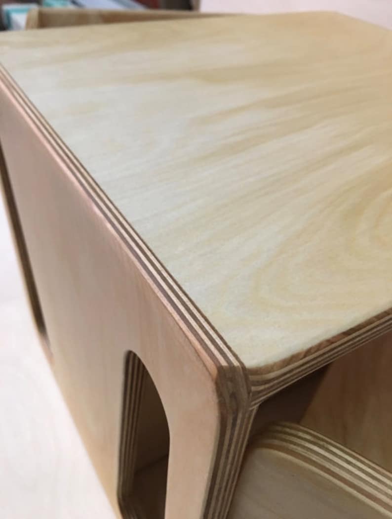 May include: A wooden storage box with three compartments. The box is made of light-colored plywood with visible layers. The top of the box is smooth and flat.