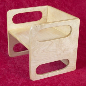 May include: A wooden step stool with rounded cutouts on the sides. The stool is made of light wood and has a natural finish.
