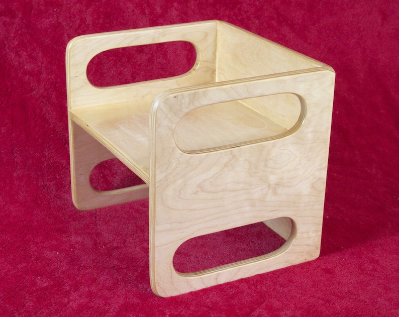 May include: A wooden step stool with rounded cutouts on the sides. The stool is made of light wood and has a natural finish.
