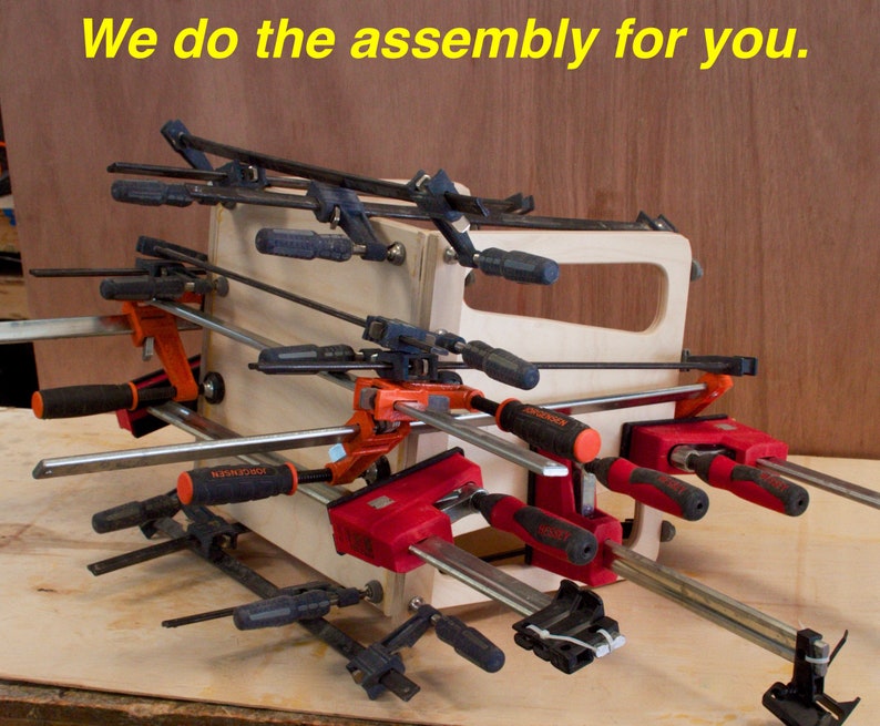 May include: A wooden box held together with various clamps. The clamps are black, red, and orange with silver bars. The text "We do the assembly for you" is in yellow at the top of the image.