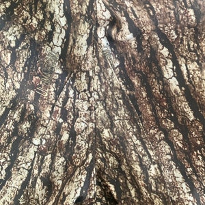 Puede incluir: Primer plano de una tela de camuflaje marr&oacute;n y tostado con el texto "ULTIMATE CAMO" impreso en el lado izquierdo y "CAMO" impreso en el lado derecho.