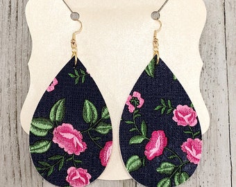 May include: A pair of teardrop-shaped earrings with a navy blue background and pink floral embroidery.