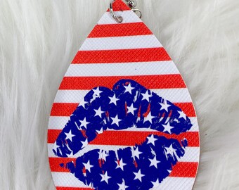 May include: Red, white, and blue teardrop-shaped earrings with a blue and white star-covered lip print.