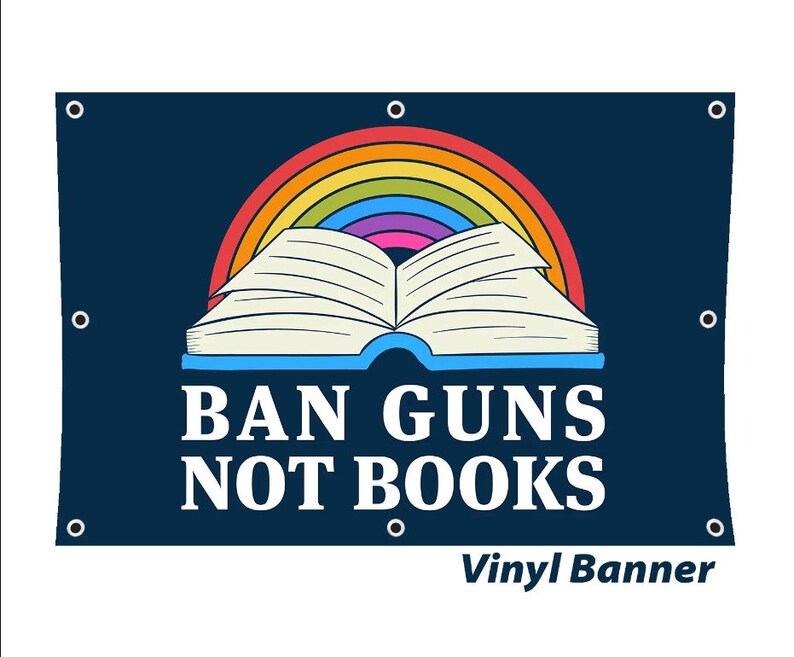 May include: A blue vinyl banner with a rainbow and an open book. The text on the banner reads "BAN GUNS NOT BOOKS".