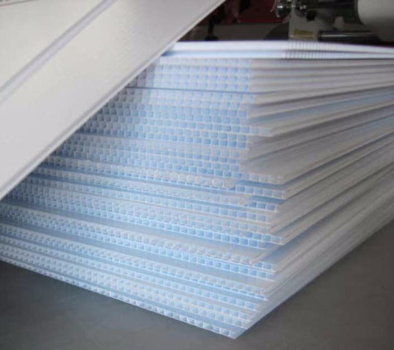 May include: A stack of white corrugated plastic sheets. The sheets are translucent and have a grid pattern.