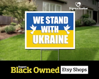 Könnte beinhalten: Ein blaues und gelbes Schild für den Garten mit weißen Tauben und dem Text "We Stand With Ukraine".