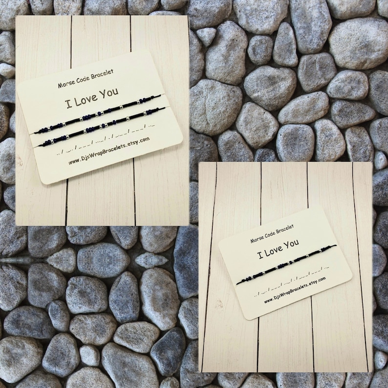 Pu&ograve; includere: Due braccialetti di amicizia neri e argentati con il messaggio "Ti amo" in codice Morse. I braccialetti sono esposti su una superficie di legno con sfondo bianco. &Egrave; anche visibile il testo "Braccialetto in codice Morse" e "www.DjsWrapBracelets.etsy.com".