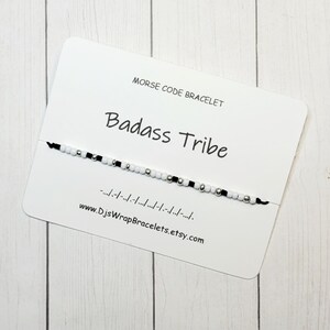 May include: A black and white beaded bracelet with the words "Badass Tribe" and the morse code translation on a white card. The card also includes the website "www.DjsWrapBracelets.etsy.com".
