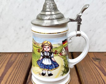 Jarra de cerveza alemana antigua con tapa de peltre y escena de pueblo de cerámica, 22,2 cm (8,75 pulgadas)
