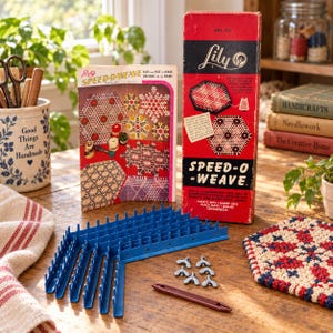 May include: A vintage Lily Speed-O-Weave craft kit featuring a tall red and black cardboard box with white text, an instructional booklet, blue plastic loom frame components, six metal wing nuts, and a brown plastic weaving needle.