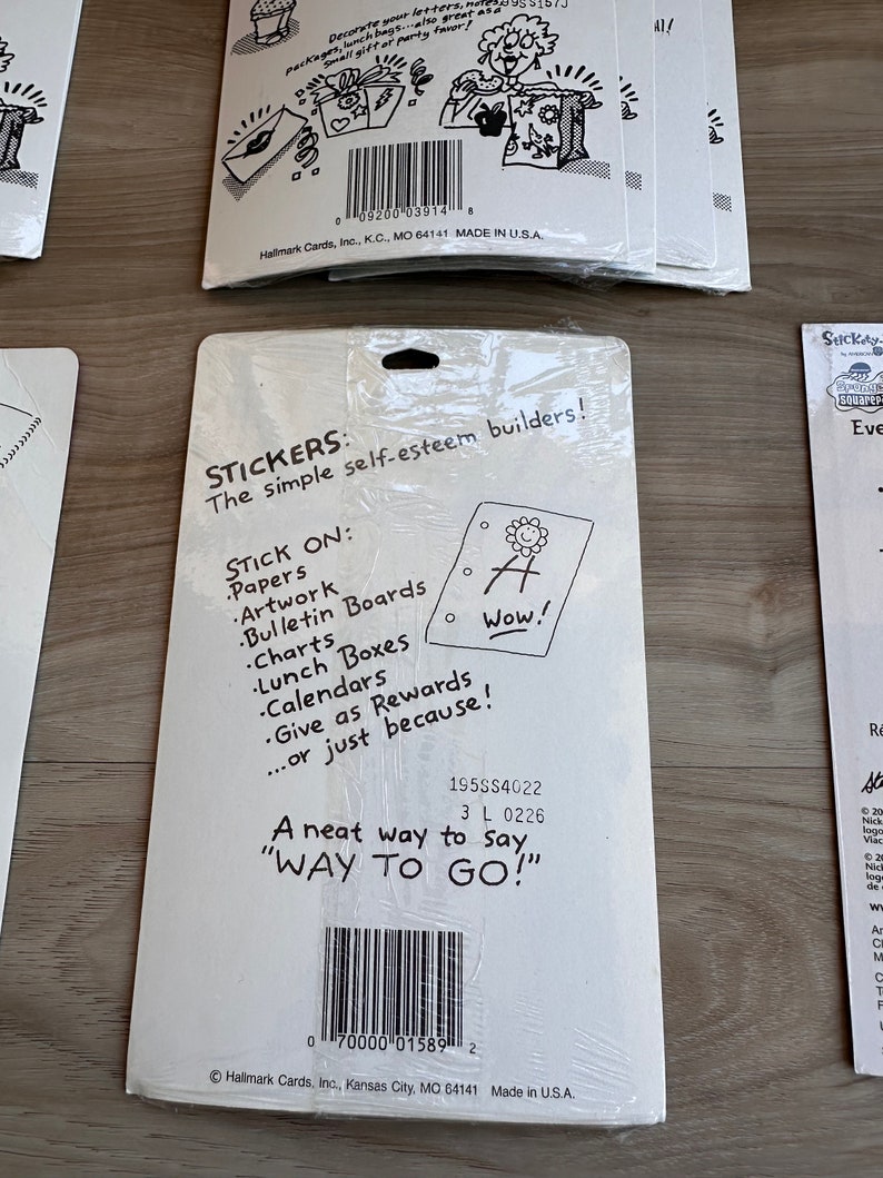 K&ouml;nnte beinhalten: Eine Packung Aufkleber mit einem farbenfrohen Design. Die Aufkleber zeigen verschiedene positive Botschaften, wie "Wow!" und "Way to Go!" Die R&uuml;ckseite der Packung enth&auml;lt Anweisungen zur Verwendung der Aufkleber und eine Beschreibung ihres Zwecks: "Die einfachen Selbstwertgef&uuml;hl-Builder!"