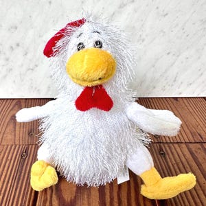 May include: A set of three ceramic mugs with a speckled, matte finish. The mugs are in shades of cream, light brown, and dark brown. Each mug has a simple, minimalist design and a rounded handle.