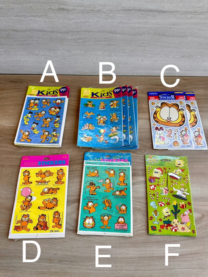 K&ouml;nnte beinhalten: Neun Bl&auml;tter mit Garfield-Stickern. Die Stickerbl&auml;tter sind bunt und zeigen Garfield in verschiedenen Posen. Die Stickerbl&auml;tter sind mit "Kids Stickers" und "Garfield Sticker" beschriftet und kosten 99 Cent.