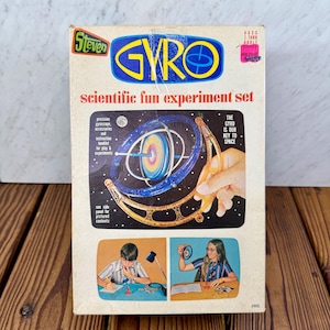 May include: Vintage "Steven GYRO" scientific fun experiment set. The box features a colorful illustration of a gyroscope and the text "scientific fun experiment set". Includes precision gyroscope, accessories, and instruction booklet. Ages 7 thru adult.