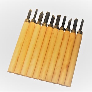 May include: A set of 12 wood carving tools with wooden handles and different shaped metal blades.