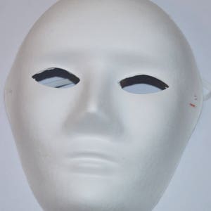 May include: A plain white mask with a smooth texture. The mask features eye cutouts, a nose, and a mouth, mimicking a human face. Suitable for costumes or theatrical performances.