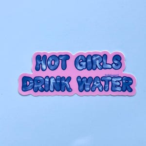 Könnte beinhalten: Rosafarbener Aufkleber mit blauem Text, der "HOT GIRLS DRINK WATER" lautet, mit einem wellenförmigen, wasserartigen Design.