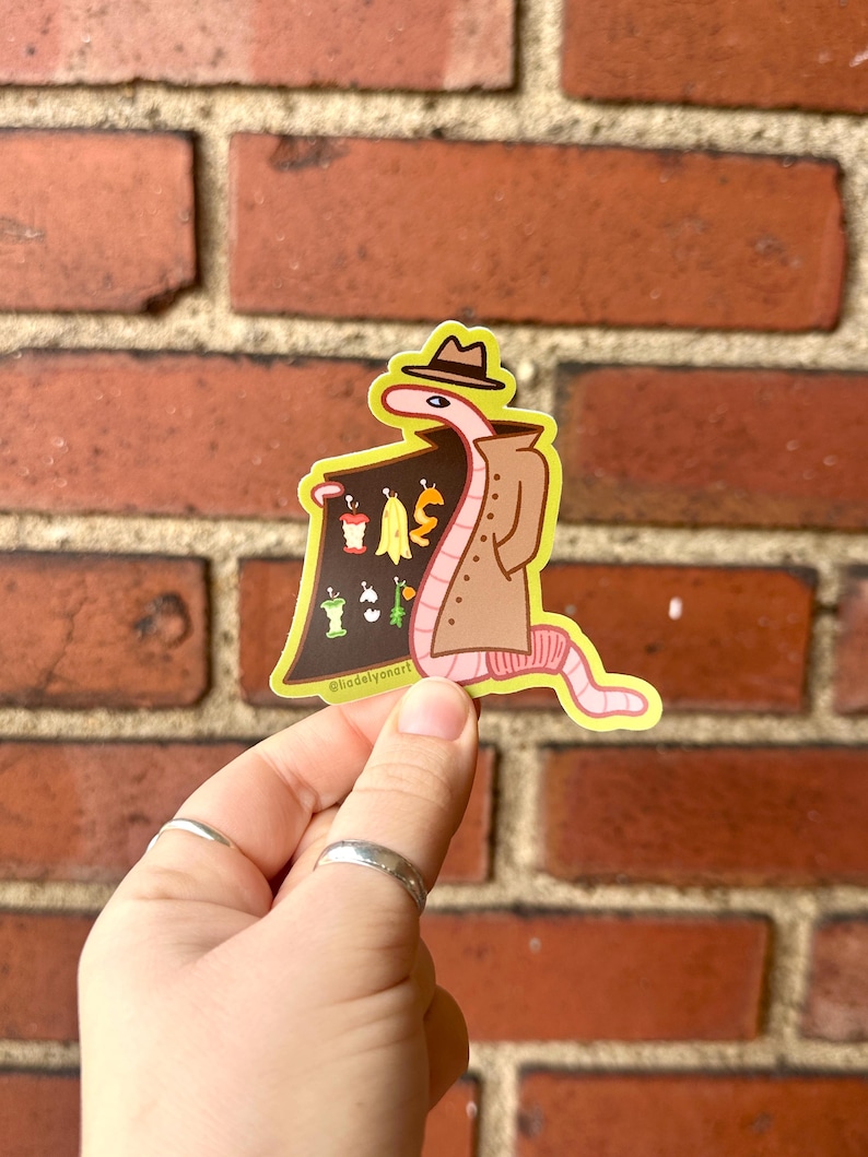 May include: A pink worm wearing a brown trench coat and a hat, holding a sign that says "WORM" and has images of various food scraps on it. The background is a brick wall.