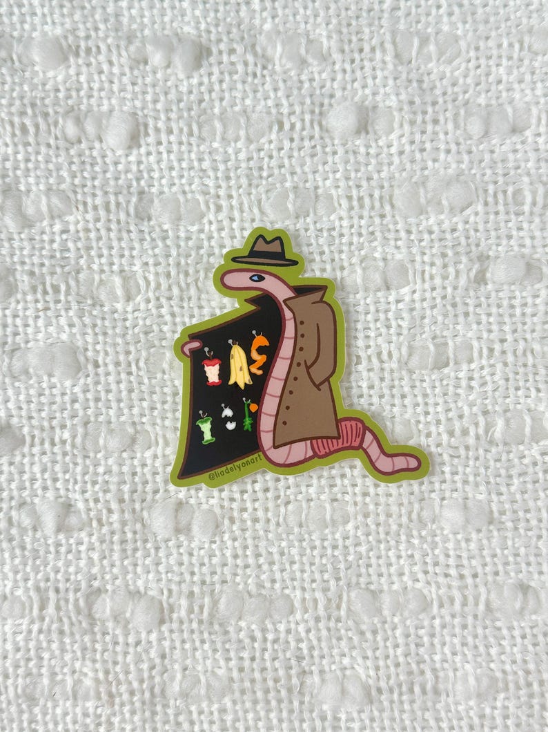 May include: A cartoon worm wearing a brown trench coat and a hat, holding a sign with a variety of fruits and vegetables. The sign is black with white text that says "@hadleysoonart".