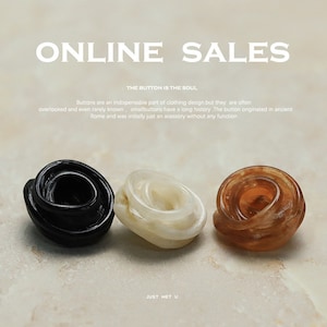 Könnte beinhalten: Drei dekorative Knöpfe in Schwarz, Weiß und Braun. Die Knöpfe sind in Spiralform gefertigt und in einer Reihe auf einer weißen Oberfläche angeordnet. Der Text "ONLINE SALES" und "THE BUTTON IS THE SOUL" befindet sich über den Knöpfen. Der Text "JUST MET U" befindet sich unter den Knöpfen.