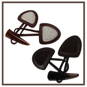 Pode incluir: Dois pares de botões de alternância de couro marrom com alternâncias de chifre. Um par tem inserções de feltro branco e o outro tem inserções de feltro marrom.