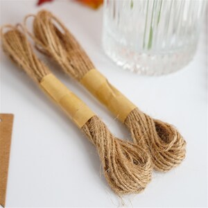 May include: Two spools of natural brown twine with paper labels. The twine is made of natural fibers and is perfect for crafting, wrapping, and decorating.