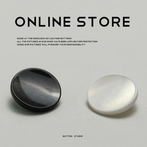 Puede incluir: Dos botones redondos, uno negro y otro blanco. Los botones tienen un acabado brillante y nacarado. El texto "ONLINE STORE" y "BUTTON STUDIO" es visible en la imagen.