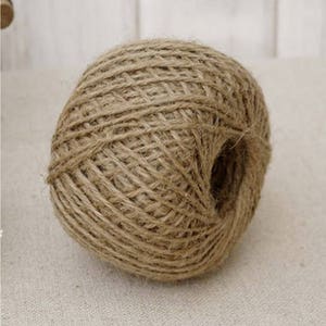 May include: A ball of natural brown twine, made from jute fibres, is ready for crafting projects.
