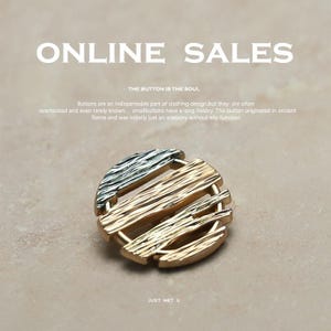 Könnte beinhalten: Nahaufnahme eines dekorativen Knopfes mit Gold- und Silber-Finish. Der runde Knopf hat ein strukturiertes Design. Der Text "ONLINE SALES" und "THE BUTTON IS THE SOUL" ist ebenfalls zu sehen.