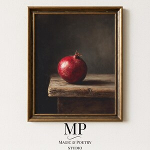Peut inclure: Impression d'art encadrée d'une nature morte avec une grenade rouge mûre posée sur une table en bois rustique. L'œuvre a une esthétique sombre et une ambiance feutrée, avec un cadre doré. Le texte "MP MAGIC & POETRY STUDIO" est en bas.