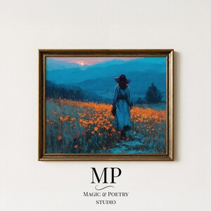 May include: A framed art print showing a person in a blue dress and hat in a field of orange flowers. The background features blue mountains and a sunset. The print is in a gold-coloured wooden frame. The text "MP MAGIC & POETRY STUDIO" is at the bottom.
