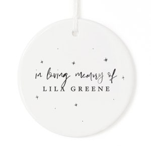 May include: White ceramic ornament with the text "in loving memory of LILA GREENE" and small star accents.