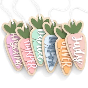 Op de afbeelding: Zes houten wortelvormige labels met namen: Hayking, Harper, Barrett, Watson, Oliver en Judy. Elk label heeft een groene bladtop en een pastelkleurig wortellichaam. Witte draad is bevestigd om op te hangen.
