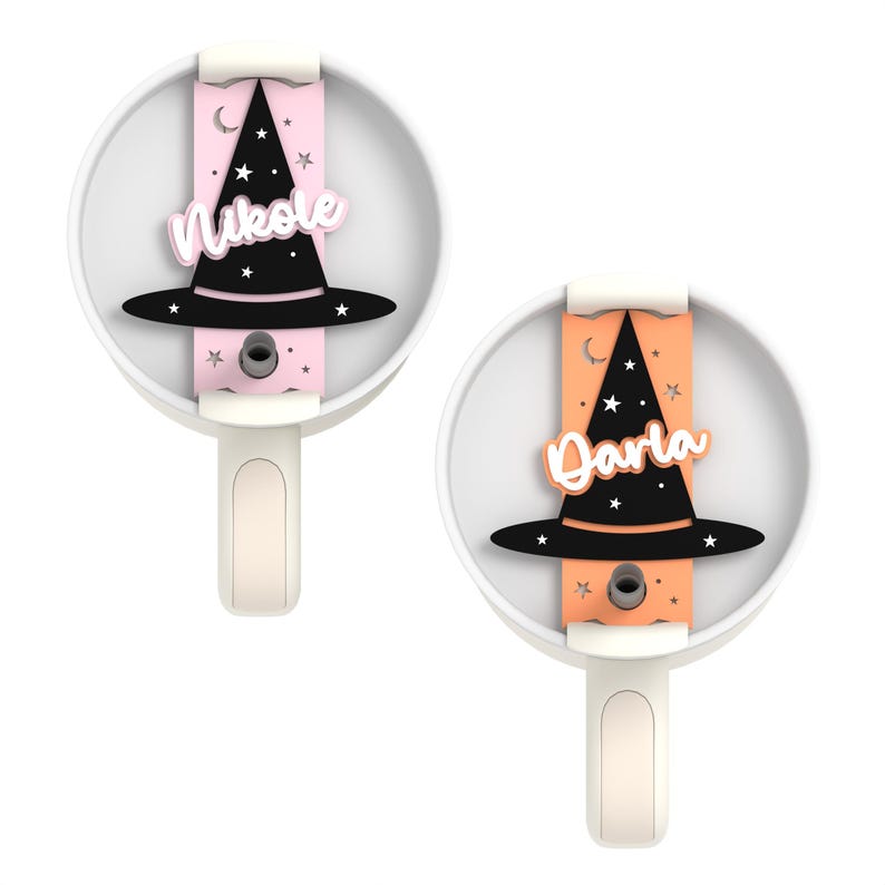 May include: Two white ceramic hooks with a black witch hat and a name on each. The hook on the left has a pink background with the name "Nikole" and the hook on the right has an orange background with the name "Darla".