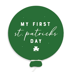 May include: Green balloon with white text that reads "My First St. Patrick's Day" and a shamrock.