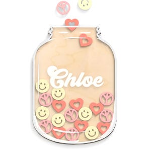 May include: A wooden jar-shaped decoration with the name "Chloe" in white script. The jar is filled with pink hearts, yellow smiley faces, and pink peace signs. Several of the same shapes are floating above the jar.