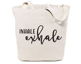 May include: A white canvas tote bag with black text that reads "INHALE exhale".