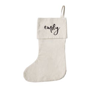 May include: A plain white Christmas stocking with a black cursive name "emily" on the cuff.