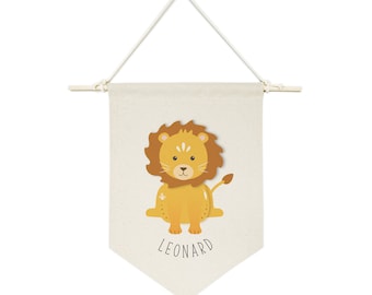 Może przedstawiać: Beżowy baner z płótna z uroczą kreskówkową ilustracją lwa i nadrukowanym czarnym tekstem "LEONARD".