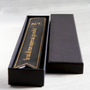 Elegante zwarte bladwijzer met gouden reliëfopdruk, inclusief geschenkdoos.