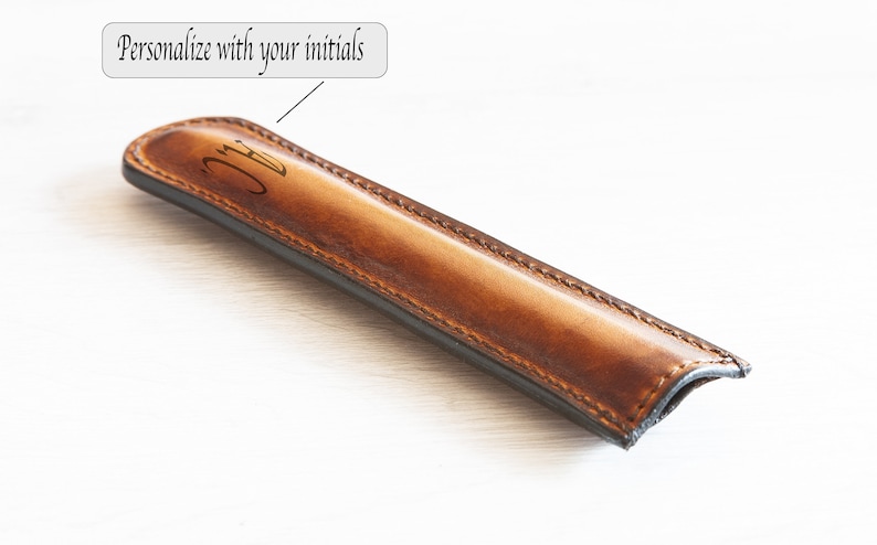 May include: A brown leather pen case with a black lining and the initials "JC" engraved on the front. The text "Personalize with your initials" is visible in the image.