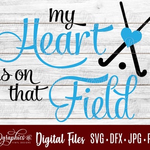 Może przedstawiać: Niebiesko-czarny projekt graficzny z tekstem "My heart is on that field" i sercem z dwoma skrzyżowanymi kijami hokejowymi z tyłu.