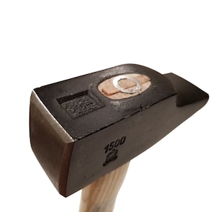 May include: A black metal hammer with a wooden handle. The hammer head has a round hole in the top and the text "1500" is stamped on the side.