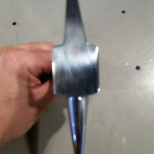 May include: A silver metal hammer with a pointed head and a long handle.