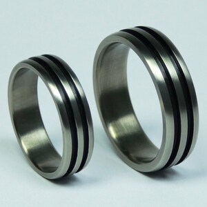 Pair of pure zirconium weddingrings, engagementrings. Zirconium rings black grooves. Zirconium rings, bands.