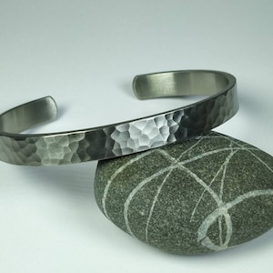 Handgehamerde titanium armband van klasse 1.