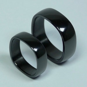 Pair of black oxidized pure zirconium engagement rings. Zirconium jewelry.