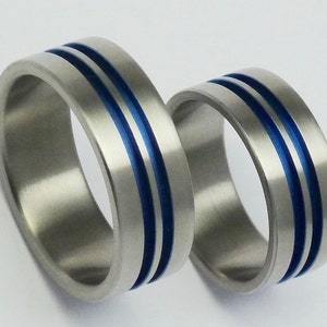Pair of anodized titanium engagement rings. Titanium weddingrings. Anodized flat titanium bands.