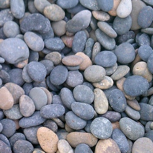 May include: A close-up of a collection of smooth, grey and brown river rocks. The rocks are various sizes and shapes, and they are arranged in a random pattern.